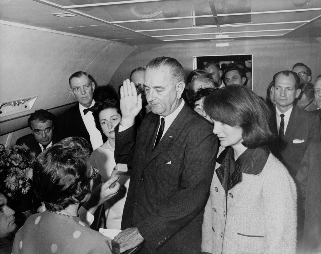 Sid Davis is just barely visible in this iconic photo of Lyndon Johnson's swearing-in: His face is pointed downward, looking at his reporters' notebook, in-between the three men on the right.