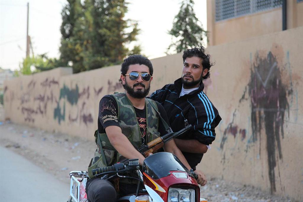 Rebels ride a motorcycle in northern Syria