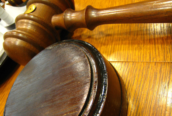 A gavel resting on its side on a desk