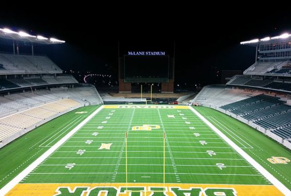 Looking down the Baylor football field from the end zone at night.