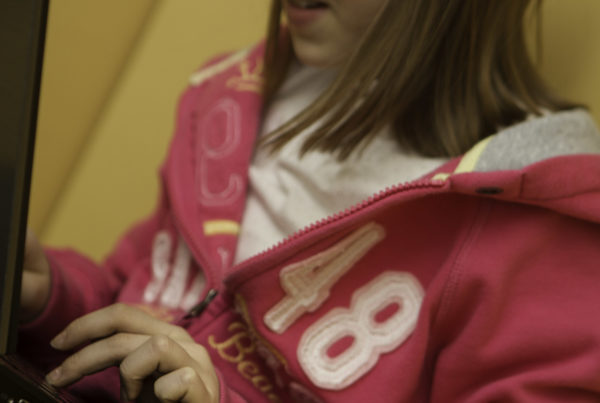 person in pink sweatshirt on computer