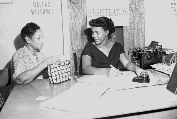 Two Black women sitting at a voter registration table.