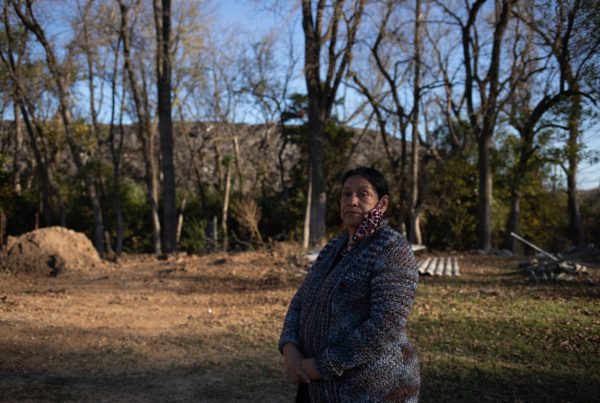 Cecilia Del Toro Garcia stands in her backyard in front of a toxic waste dump