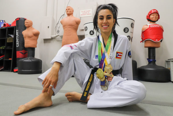 a young female taekwondo Olympian with medals around her neck