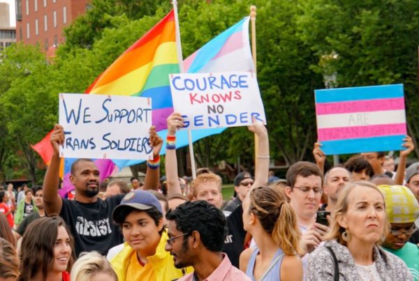 protesters in support of transgender service in the military carrying signs and flags