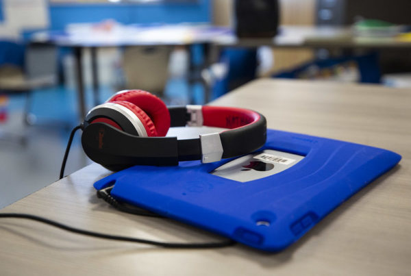 a pair of headphones rests on an iPad