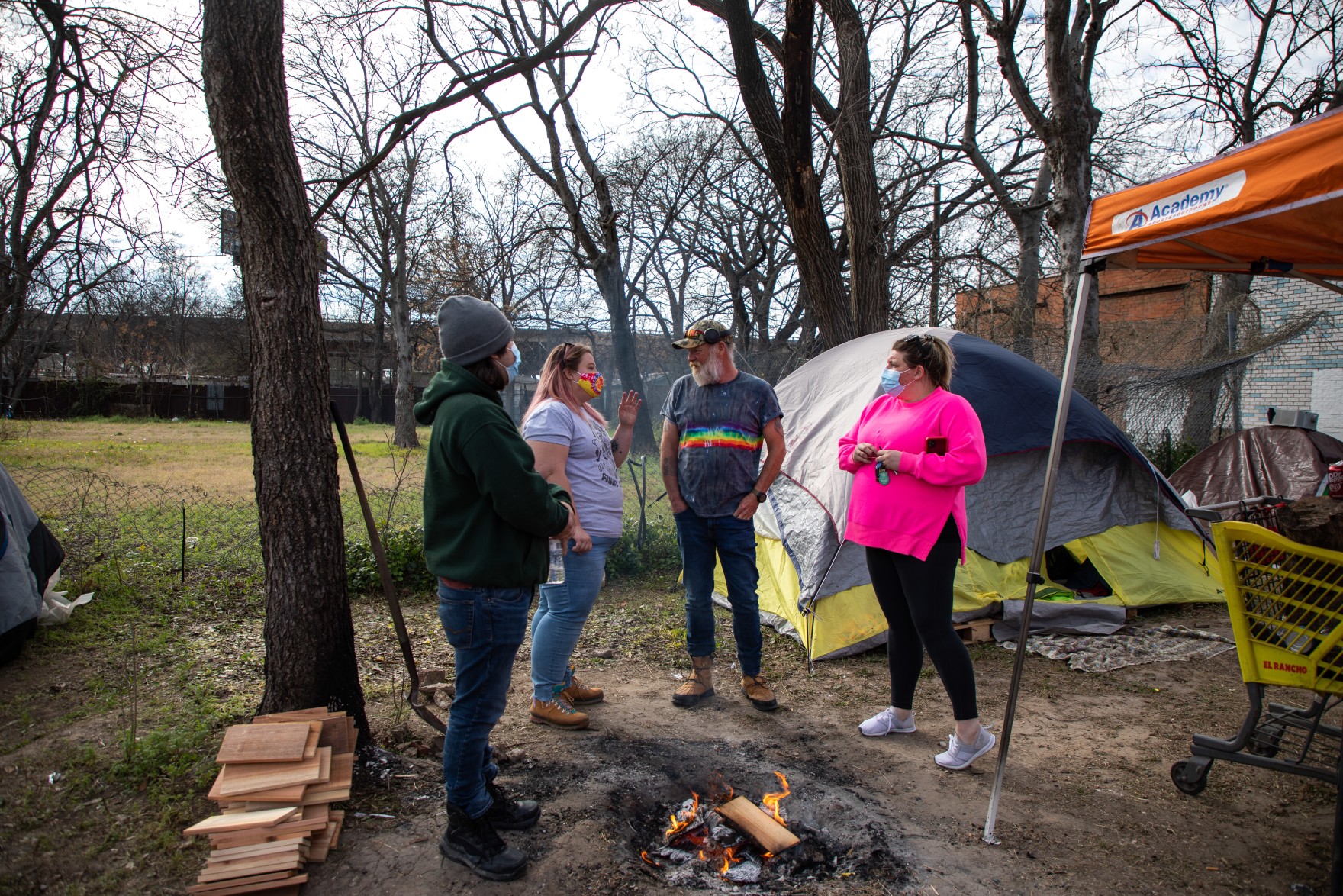 aid volunteers standing at a camp for the homeless