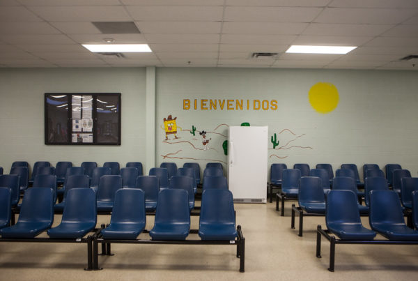 an immigrant detention center with rows of blue chairs