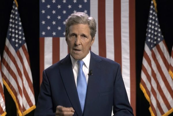 john kerry in front of american flags