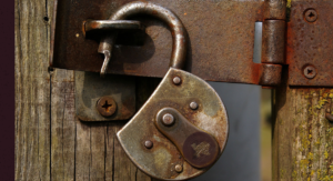 A rustic lock open on an old door.