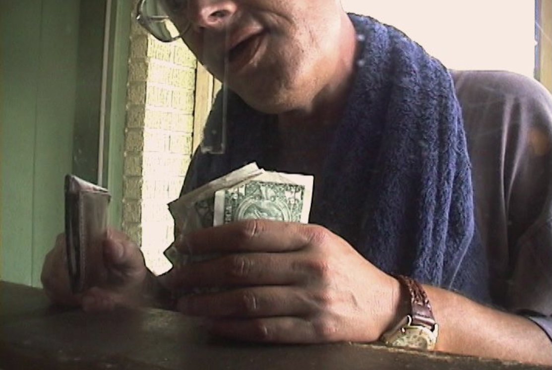a man with a towel around his neck holding money