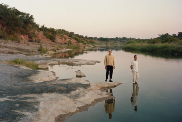 Two people standing on rocks in a river