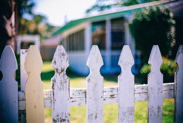 a house through a worn picket fence