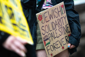 a protest sign reads "Jewish solidarity with Palestine forever."
