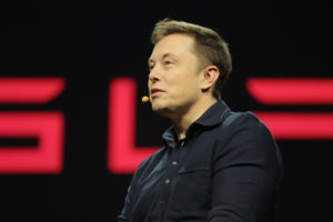 Elon Musk in profile, from mid-chest, up