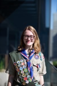 a young female eagle scout with her sash and badges
