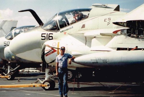 a man standing in front of a fighter plane