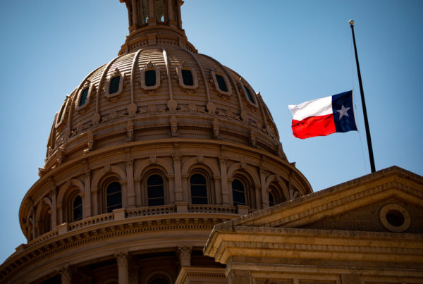 the texas capital dome with a texas flag in front of it