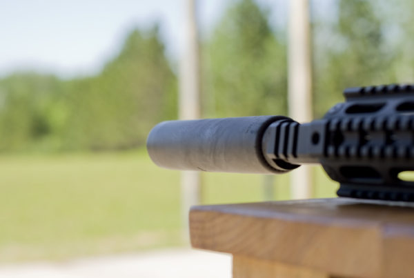 a close-up photo of a gun with a silencer attached