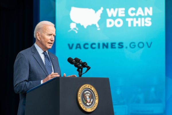 President Biden at a podium with a vaccines dot gov sign also visible