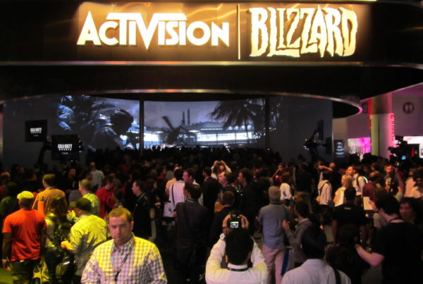 a crowd, viewed fromthe back, gathers at an Activision Blizzard trad show booth