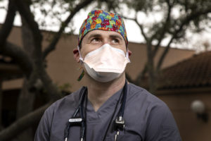 Dr. Michael Krol wears a face mask and medical scrubs