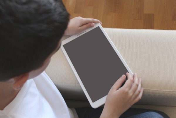 An unidentified child looks at a blank computer tablet