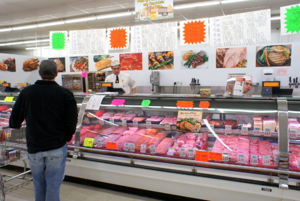 a grocery store meat counter with a person standing in front