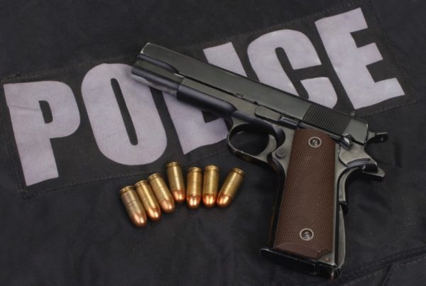 Colt government m1911 handgun with ammo on police uniform