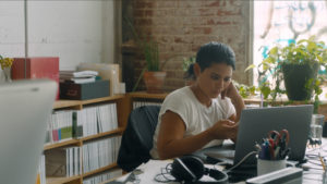 a young Latina works at a desk