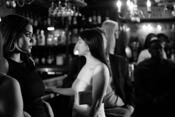 a black-and-white photo of young women standing at a bar