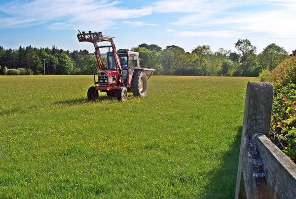a long shot of a fertilizer spreader in a field