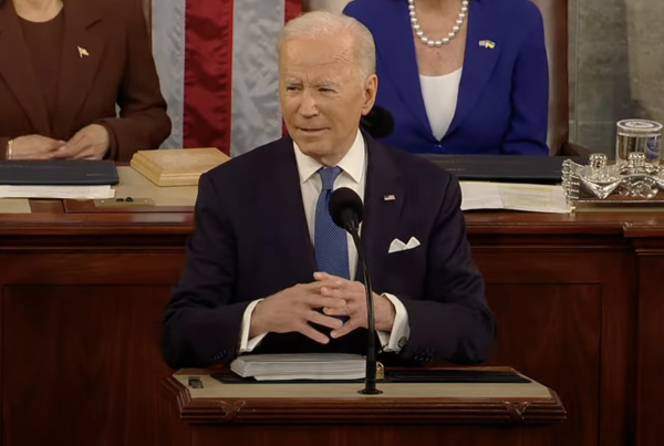 a screenshot from Biden's State of the Union address shows Biden at the podium during his address