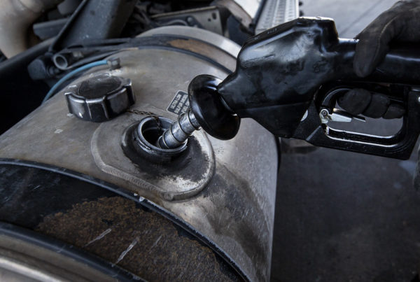 a person fills a large diesel tank with gas wearing a thick glove