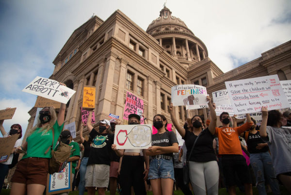 Protesters stand in front of the Texas Capitol holding signs in support of abortion rights