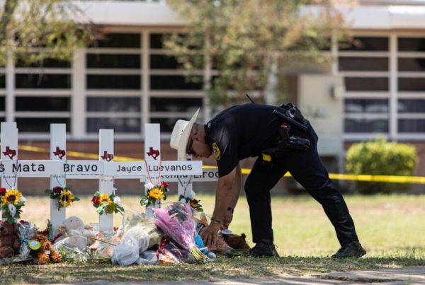 A law enforcement officer in Uvalde visits a memorial for the victims of the shooting at an elementary school.