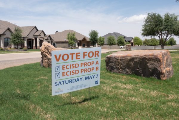 a large campaign sign that says "Vote for ECISD Prop A and "ECISD Prop B"