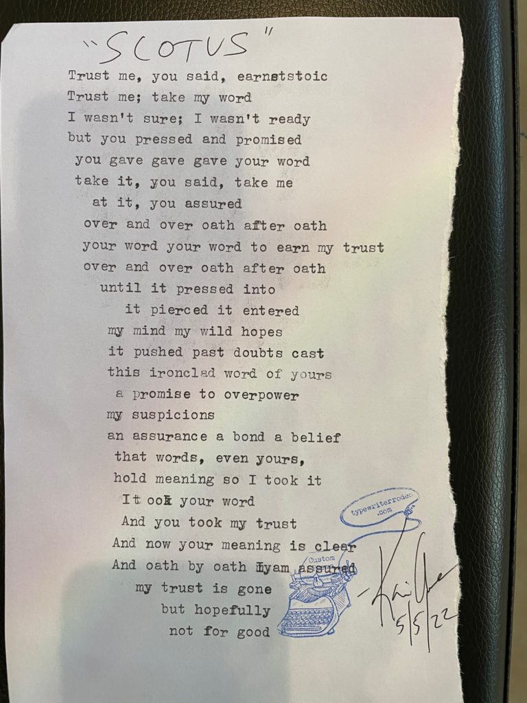 a photo of the typewritten poem on a torn piece of light purple paper with a subtle rainbow through the center