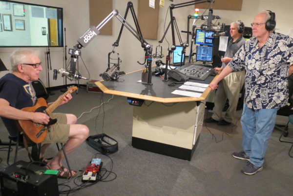 People in a radio studio, seated for an interview