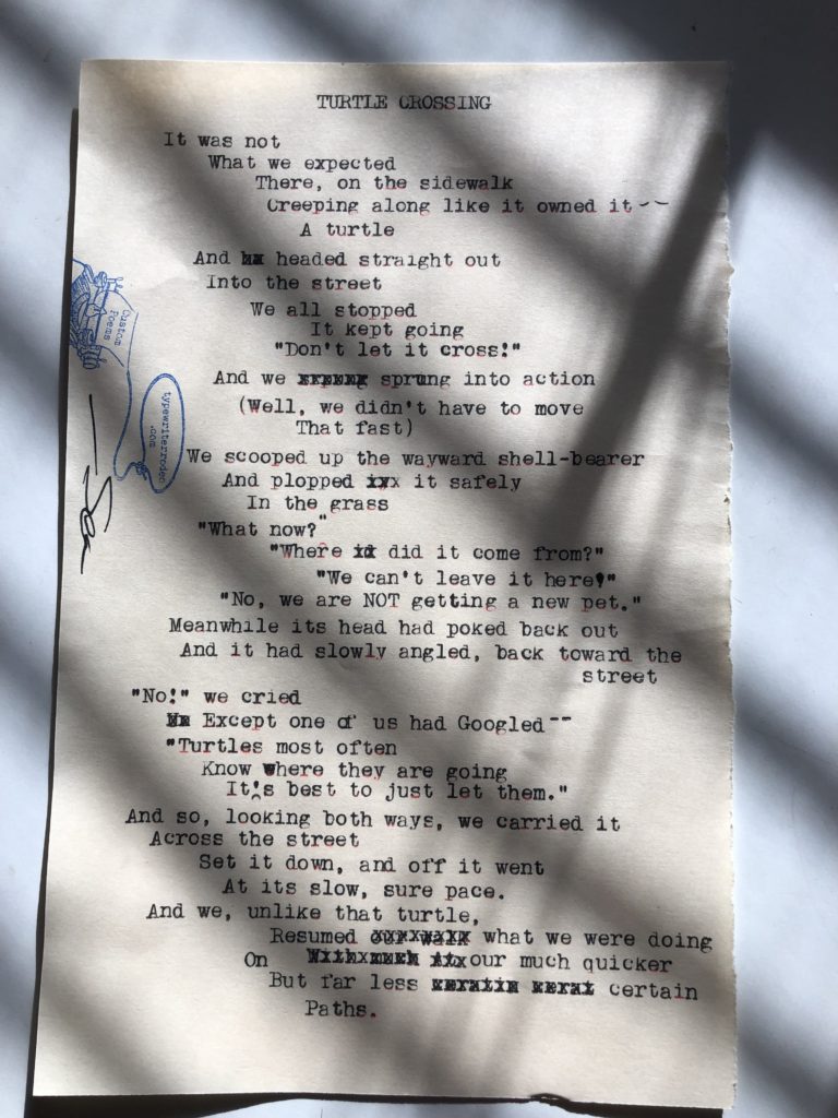 A photo of the typewritten poem on a half sheet of torn, off-white paper. The sun through window blinds are making a stark shadow on the paper.