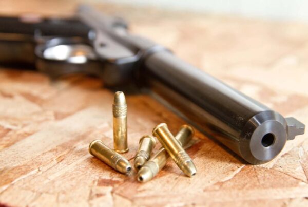 A close-up of a handgun and bullets on a table