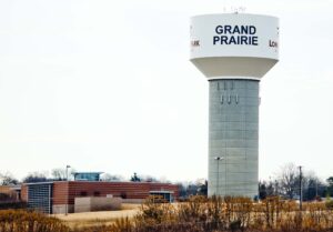 A water tower that says "Grand Prairie" in blue letters