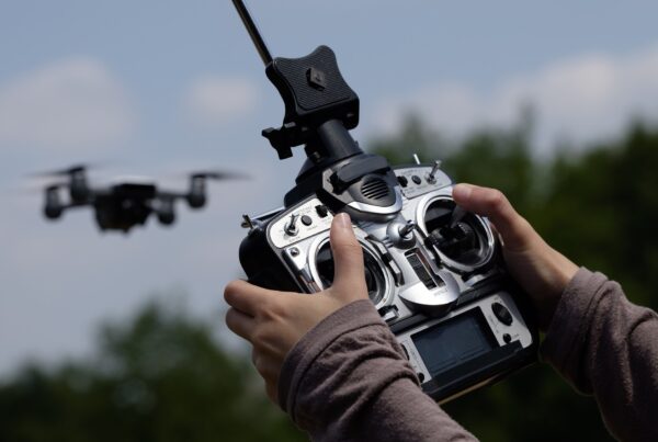 A close-up photo of a person's hands controlling a high-tech flying drone of some sort.
