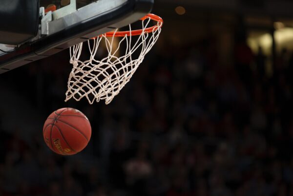 Close-up shot of a basketball hoop with a ball exiting the net