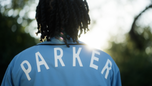 a close up photo of the back of a light blue jersey with the name Parker in white letters