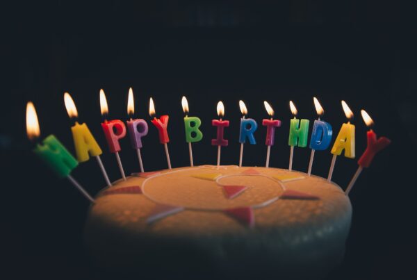 a photo of a cake with lit candles that spell out "happy birthday"