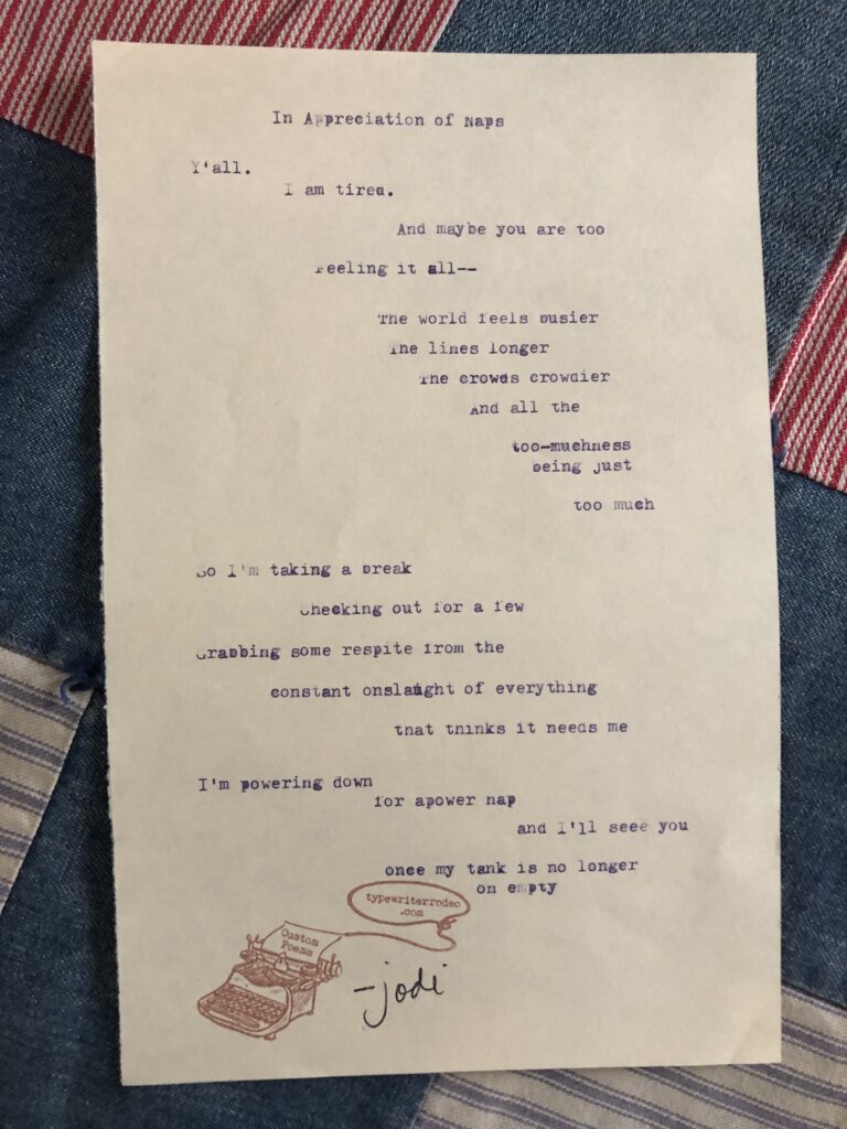 a photo of the typewritten poem on a torn piece of light yellow paper. the paper is sitting on top of a quilt.