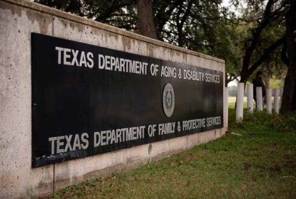 An outdoor building sign says "Texas Department of Aging & Disability Services" above "Texas Department of Family & Protective Services"
