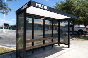 A bus shelter is seen, the word "METRO" appearing on the top paneling.