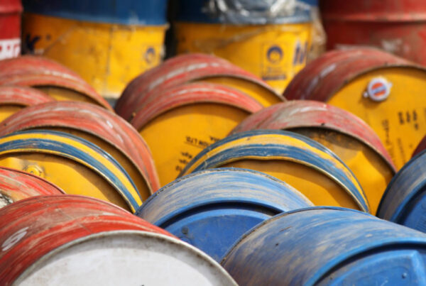 A close-up of many gold-red and blue oil barrels